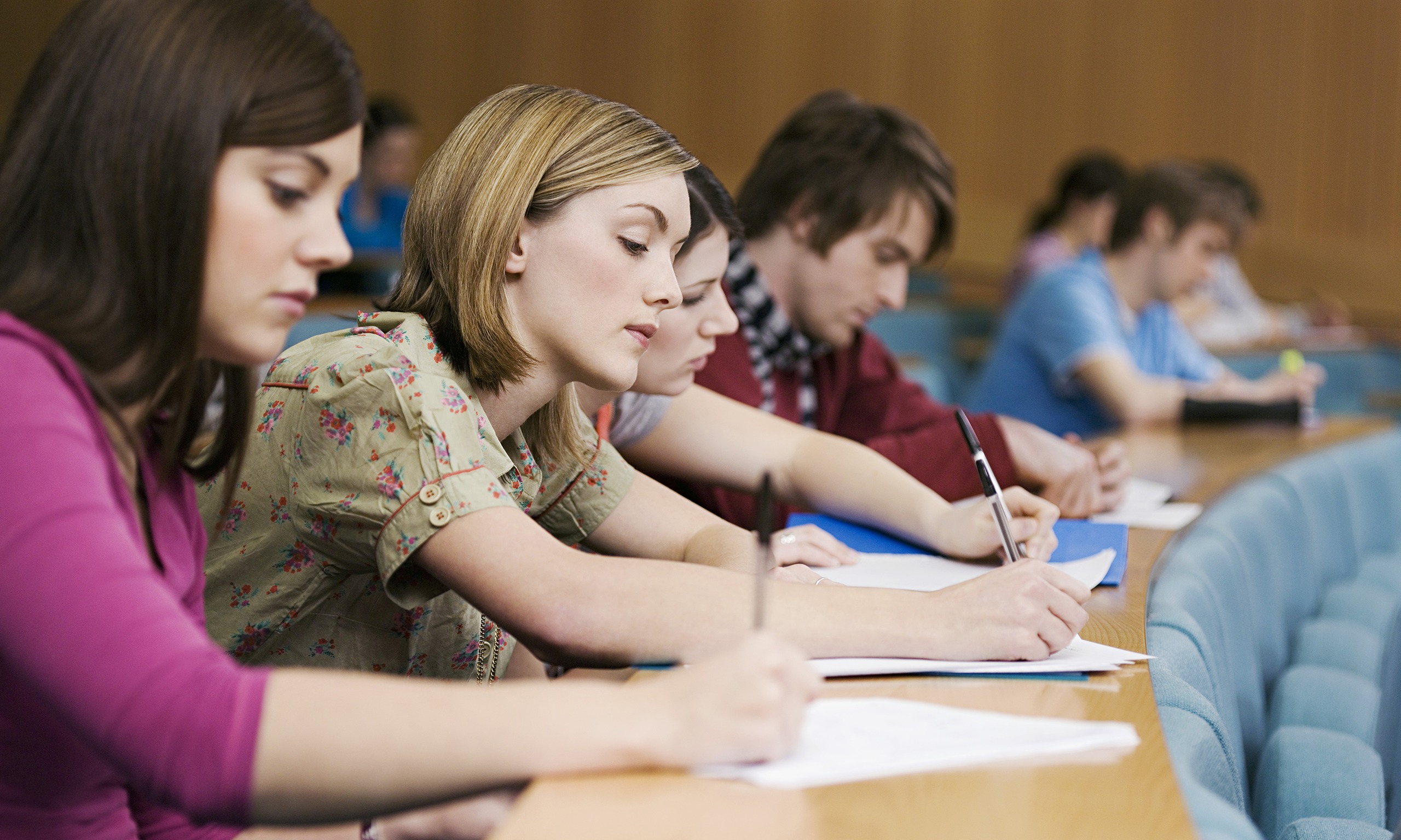 University students take notes in a lecture hall